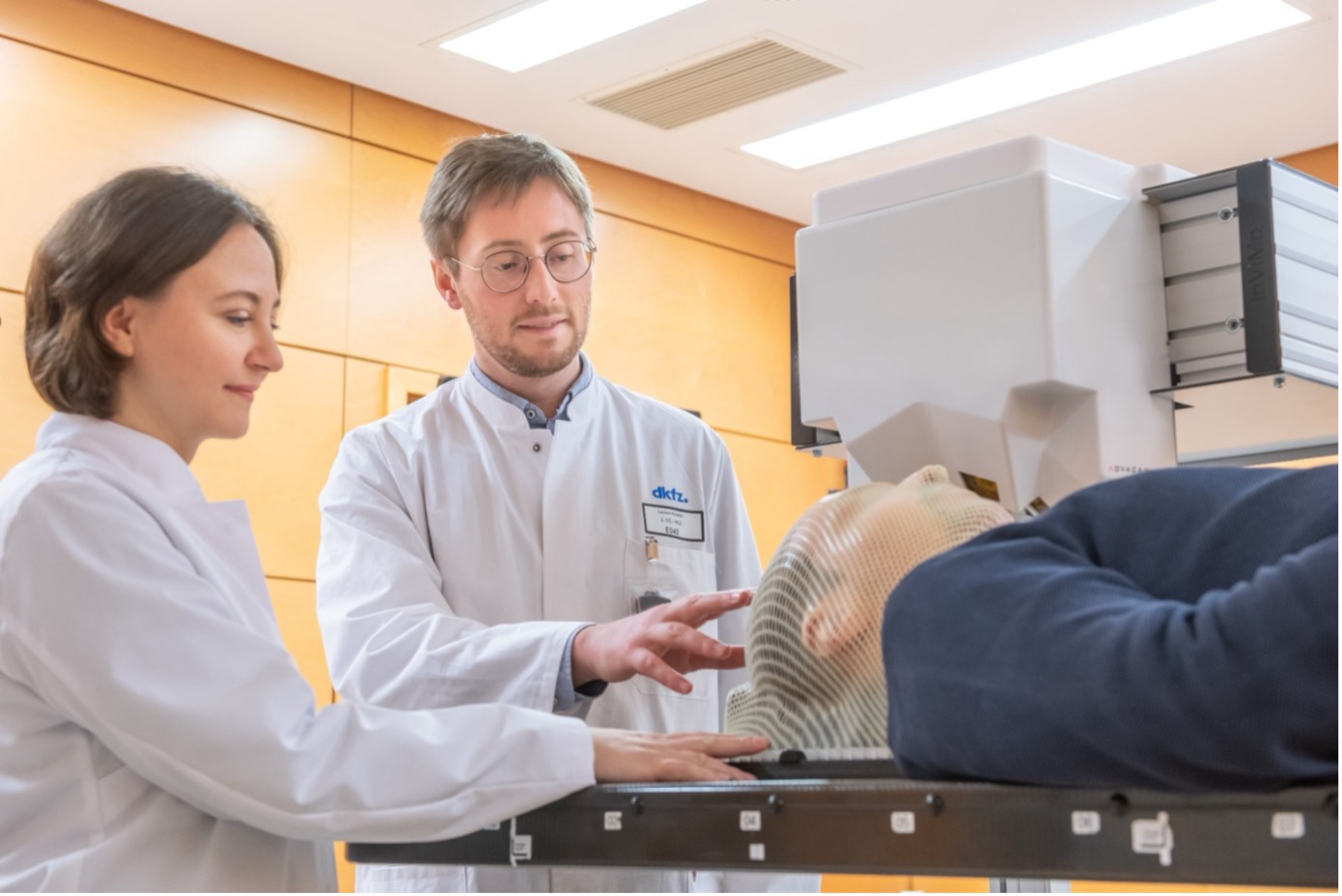 two scientists in a medical examination room with a patient